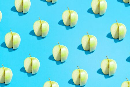 Minimal flat lay food texture. Summer abstract trendy fresh concept. green sliced Apple pattern on bright light blue background, copy space.の写真素材