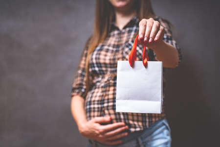 pregnancy shopping, motherhood, people and expectation concept - pregnant woman with shopping bag...