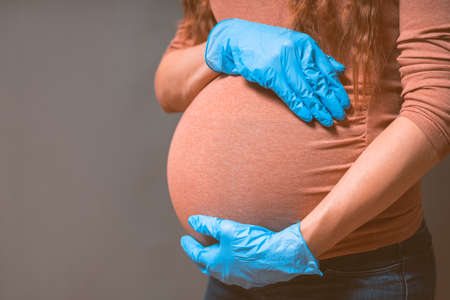 Pregnant Woman in blue gloves against flu and viruses. Healthcare concept. Pregnancy And Infection concept.の写真素材