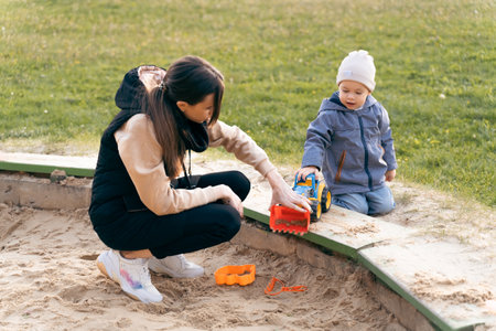 Mother and son playing in sandbox. Little builder. Education, and imagination, purposefulness...