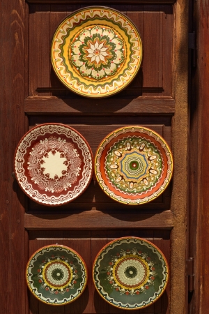 Painted pottery dishes in oriental style at wooden standの写真素材