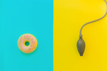 Flat lay stress, antistress: toy squish pink donut, sprinkles, blood pressure monitor.Bright blue background.Compressing soft squeezable items to relieve, problems, anxieties,worries.Summer concept.の写真素材