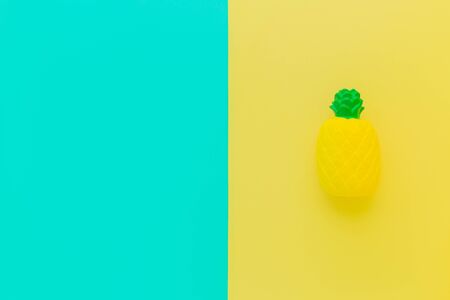 Flat lay antistress toy squish in form of yellow pineapple with green leaves.Bright blue...