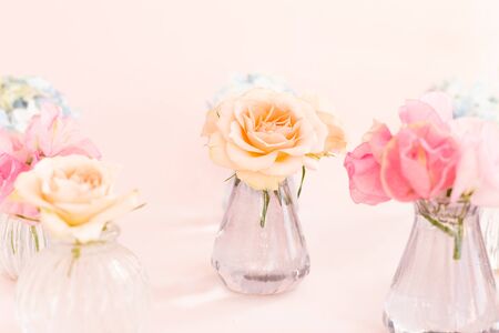 Decoration of blooming blue hydrangea, sweet pea Lathyrus, bush roses in small crystal vases on pink background. Design, Creative. International Women's Day,March 8 and Valentine's Day,14 of February.の写真素材