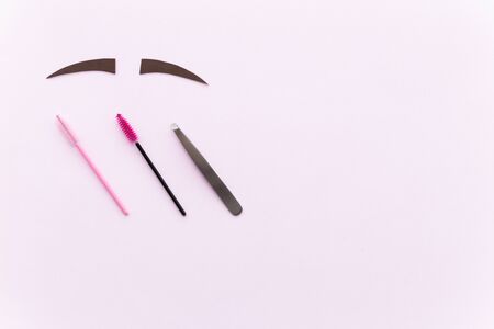 Flat lay: beauty accessories for coloring, plucking and shaping eyebrows. Decorative carved brown brows, brushes, tweezers on a pink background.の写真素材