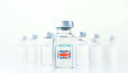 Transparent vials with UK flag. Vaccine for covid-19 coronavirus, flu, infectious diseases. Injection after clinical trials for vaccination of human, child, adult, senior. Medicine, drug concept.の写真素材