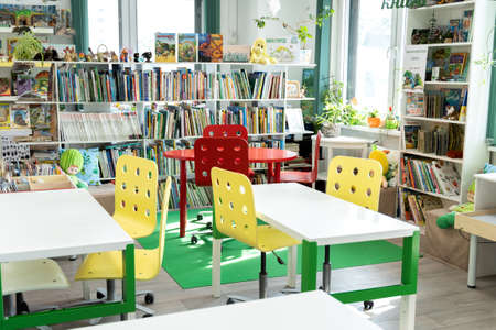 Russia Moscow 25.09.20 Children's city library. Special reading room for kids with bright green, red, yellow tables, chairs. Many shelves with interesting, educational books with animals, fairy tales.のeditorial素材