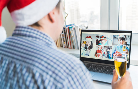 Family online video conference, christmas greetings. Virtual call through screen of laptop, tablet, mobile phone. Glass of champagne, gift. Remote conversation with mom, wife, children.Home isolation.の写真素材