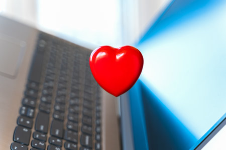 Big red heart on laptop keyboard. Valentine's day holiday concept. Online love, remote communication on internet, social networks.の写真素材