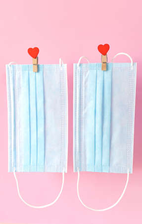Blu protective face masks flying on clothespins with hearts on rope.Valentine's day for lovers, couplesの写真素材