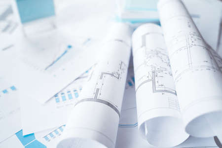 Business project documentation, development, planning and approval. Construction drawings for building, apartment, financial diagrams, investment plan, documents. Making repairs. Blurred background.の写真素材