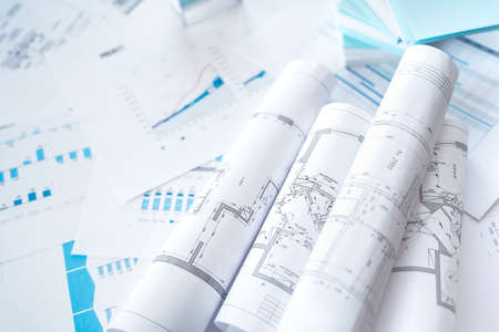 Business project documentation, development, planning and approval. Construction drawings for building, apartment, financial diagrams, investment plan, documents. Making repairs. Blurred background.の写真素材