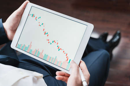 Businessman, investor,trader analyzing,looking at chart of stock prices in tablet. CEO,general...