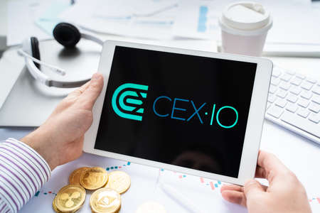 Russia Moscow 05.05.2021 Businessman holding tablet with logo of cryptocurrency stock exchange...