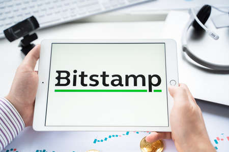 Russia Moscow 05.05.2021 Businessman holding tablet with logo of cryptocurrency stock exchange Bitstamp.Buy, sell, change crypto coins, diital money BTC, Bitcoin, ETH, Ethereum.Trading, investing to tokens.のeditorial素材