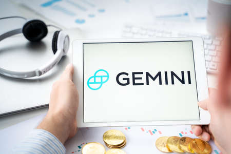 Russia Moscow 06.05.2021.Businessman with tablet.Logo of cryptocurrency stock exchange Gemini.Trading blockchain platform to buy,sell digital crypto coins,tokens Bitcoin,Ethereum.Business,investing.のeditorial素材