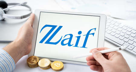 Russia Moscow 05/06/2021 Businessman with tablet.Logo of cryptocurrency stock exchange Zaif.Trading blockchain platform to buy, sell digital crypto coins, tokens Bitcoin, Ethereum.Business, investing.のeditorial素材