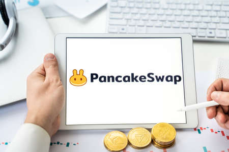 Russia Moscow 05/06/2021 Pancake swap logo.Cryptocurrency decentralized exchange DEX, tablet.Trading blockchain platform to swap, buy, sell crypto token, digital coin Bitcoin, Ethereum.Business, investing.のeditorial素材