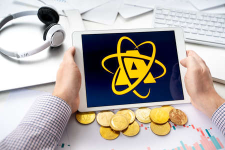 Russia Moscow 06.05.2021.Man holding tablet with logo of NFT marketplace Atomic market. Non fungible...