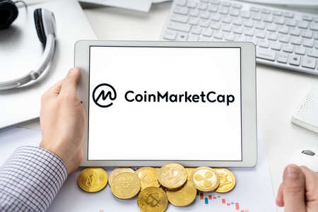 Russia Moscow 06.05.2021.Tablet with logo of Coinmarketcap, web site with rating, ranking of digital tokens, crypto coins, blockchain cryptocurrency DEX, DEFI companies, projets, wallets, exchange stocks.のeditorial素材