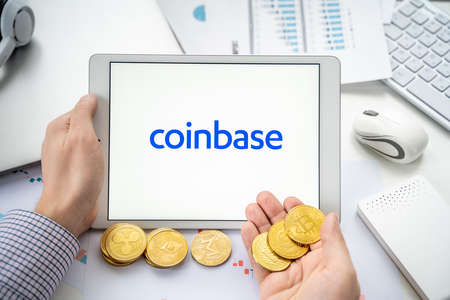 Russia Moscow 05/06/2021.Businessman with tablet.Logo of cryptocurrency stock exchange Coinbase.Trading blockchain platform to buy, sell digital crypto coins, tokens Bitcoin, Ethereum.Business, investing.のeditorial素材