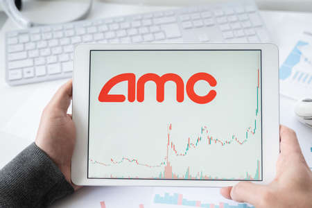 Russia Moscow 30.05.21 Tablet in hands with logo of AMC online cinemas network. Entertainment...