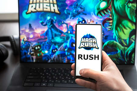 Russia Moscow 30.05.2021.Logo, screenshot of blockchain nft ethereum cryptocurrency game Hash Rush in laptop,mobile phone screen. Man playing,mining crypto coins Rush. Earning money with Lands,heroes.のeditorial素材