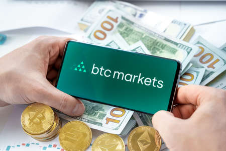 Russia Moscow 20.05.2021 Btc markets logo in mobile phone.Cryptocurrency decentralized exchange DEX.Trading blockchain platform. Buy,sell crypto token,digital coin Bitcoin,Ethereum.Business,invest.のeditorial素材