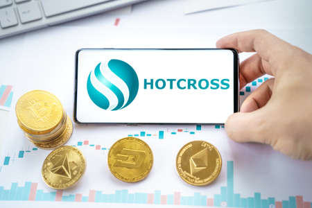 Russia Moscow 20.05.2021 Hotcross logo in mobile phone.Cryptocurrency decentralized exchange DEX.Trading blockchain platform.Swap,buy,sell crypto token,digital coin Bitcoin,Ethereum.Business,invest.のeditorial素材