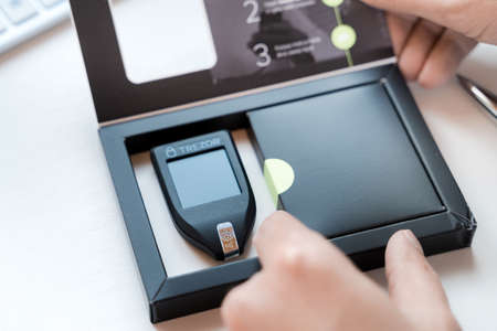 Russia Moscow 12.06.2021 Unpacking of box Trezor hardware,software pocket wallet.Accessory...