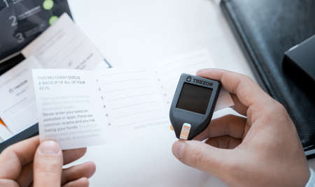 Russia Moscow 12.06.2021 Unpacking of box Trezor hardware,software pocket wallet.Accessory kit,password sheet.Safe,secure vault of cryptocurrency,coins,tokens,nft digital assets.Storage for login,key.のeditorial素材