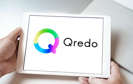 Russia Moscow 24.06.2021 Logo of Qredo in tablet. Cryptocurrency token QRDO. Trading blockchain platform to buy,sell on decentralized exchange DEX. Digital money.Business,investing.のeditorial素材