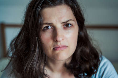 Sad, unhappy woman in depression. Headache, stress, anxiety tension, psychological problems. Poor mental health, visiting psychologist, psychotherapy session. Worries about work, family divorce.の写真素材