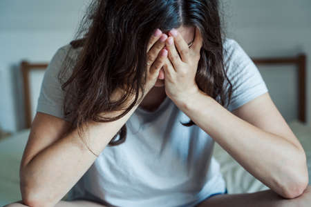 Sad, unhappy woman in depression. Headache, stress, anxiety tension, psychological problems. Poor mental health, visiting psychologist, psychotherapy session. Worries about work,family divorce.の写真素材