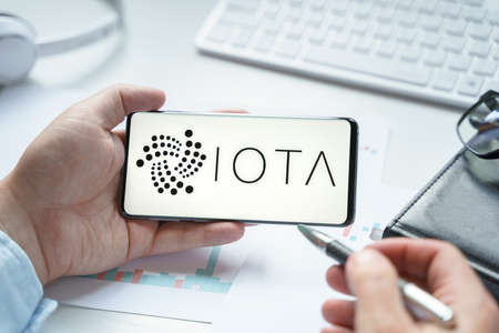 Russia, Moscow 08.06.2021.Logo of IOTA blockchain protocol in mobile phone.Distributed Ledger Technology. Facilitate microtransactions between devices on Internet of Things.Consensus algorithm Tangle.のeditorial素材