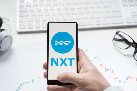 Russia Moscow 08.06.2021 Logo of public blockchain token NXT, Jelurida. Decentralized asset exchange. Issue, trade crypro coins, cryptocurrrency.のeditorial素材