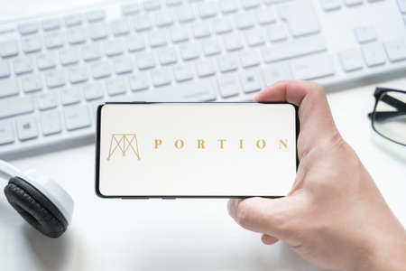 Russia Moscow 08.06.2021 Logo of Portion in mobile phone. Cryprocurrency PRT token,crypto coin. Marketplace for design, digital,physical art,nft collectibles.Through smart contracts on Ethereum, IPFS.のeditorial素材