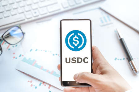Logo of stablecoin USD coin in tablet. Cryptocurrency stable coin, token. Trading blockchain platform to buy,sell on decentralized exchange DEX,DEFI. Digital money.Business,investing.のeditorial素材