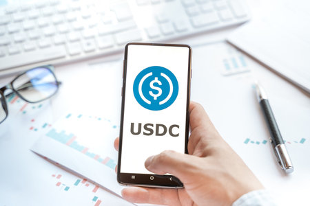 Logo of stablecoin USD coin in tablet. Cryptocurrency stable coin, token. Trading blockchain platform to buy,sell on decentralized exchange DEX,DEFI. Digital money.Business,investing.のeditorial素材