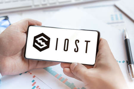 Logo of IOST coin in tablet. Cryptocurrency FTM token. Trading blockchain platform to buy,sell on decentralized exchange DEX,DEFI. Digital money.Business,investing.のeditorial素材