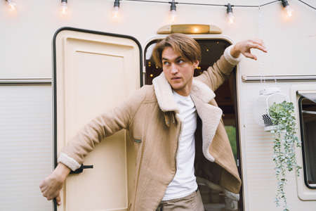 Young stylish american guy,man traveling in camper,house on wheels,trailer,motor home. Romantic road travel,freedom life. Campsite overnight in van. Wanderlust vacation, weekend. happy adventure.の写真素材