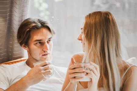 Young just married couple traveling in camper,house on wheels,trailer,motor home.Love romantic road travel,freedom life. Small bed,bedroom in van.Wanderlust vacation,weekend. Girl,guy,happy adventure.の写真素材