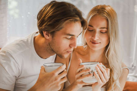 Young just married couple traveling in camper,house on wheels,trailer,motor home.Love romantic road travel,freedom life. Small bed,bedroom in van.Wanderlust vacation,weekend. Girl,guy,happy adventure.の写真素材