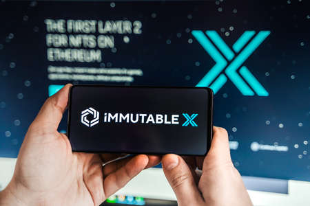 Russia Moscow 04.09.2021.Logo,screenshot of Immutable X, IMX token.Blockchain nft ethereum cryptocurrency game in laptop,mobile phone.Man playing with crypto coins.Earning digital money.Land,heroes.のeditorial素材