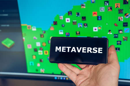 Russia Moscow 19.01.2022 Logo of metaverse. Investing in digital universe, real estate. Buy land in virtual world. Blockchain nft cryptocurrency.Man with mobile phone.Play-to-earn.Buing accessories.のeditorial素材
