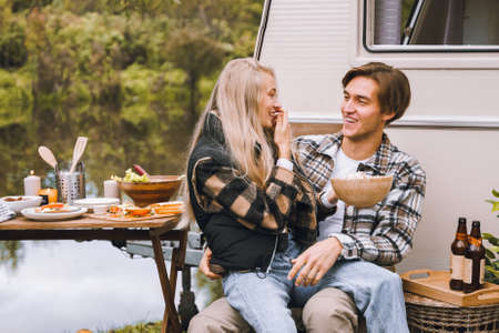 Young just married couple traveling in camper,house on wheels,trailer,motor home.Love romantic road travel,freedom life.Campsite overnight in van.Wanderlust vacation,weekend. girl,guy,happy adventure.の写真素材