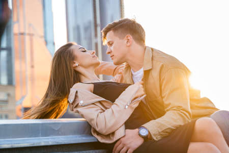 Happy young couple girl man guy on romantic love date on roof top with city skyscraper view...