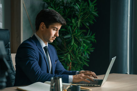 Businessman working with laptop in modern office. general manager, ceo Young handsome confident man in suit sitting at table. executive business leader. Entrepreneur career.Accountant bank workplace.の写真素材