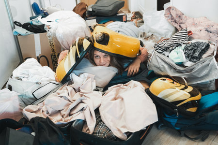 Difficult family travel preparation. Moving, packing unpacking of lot of things,clothes, suitcases, baggage at home in apartment. Many packages,bags.Mess,disorder.Gathering for vacation trip journey.の写真素材