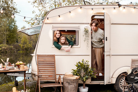 Children,family,brother sister traveling in camper,house on wheels. Trailer motor home.Looking in window. Funny road travel.Campsite van overnight.Wanderlust vacation,weekend.Girl,guy,happy adventure.の写真素材